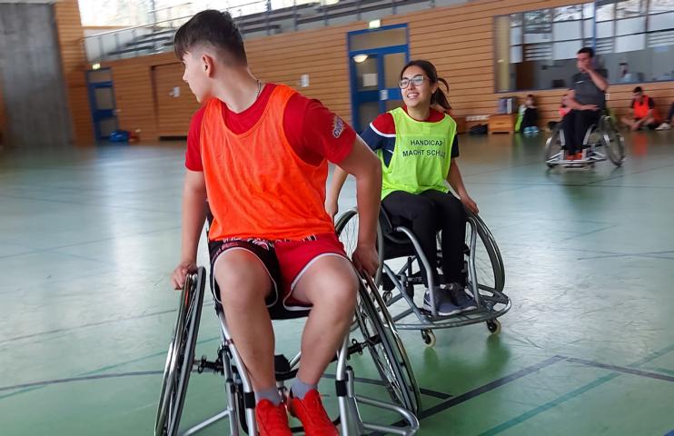Zwei Jugendliche spielen Rollstuhlbasketball