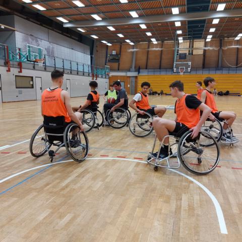 Trainer Werner Rieger erklärt Jugendlichen die richtige Aufstellung in der Verteidigung beim Rollstuhlbasketball.